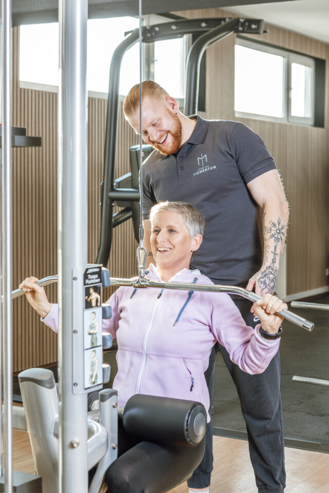 Trainierende Person am Kabelzug mit Coach im Fitness Studio 'Momentum Sports Cluv' Kirchheim unter Teck